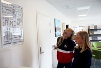 Uma Børset Bekken (t.v.) og Rachel Gulla Løfaldli studerer Åse Børsets dialektplakat med ord og uttrykk fra Rindal.